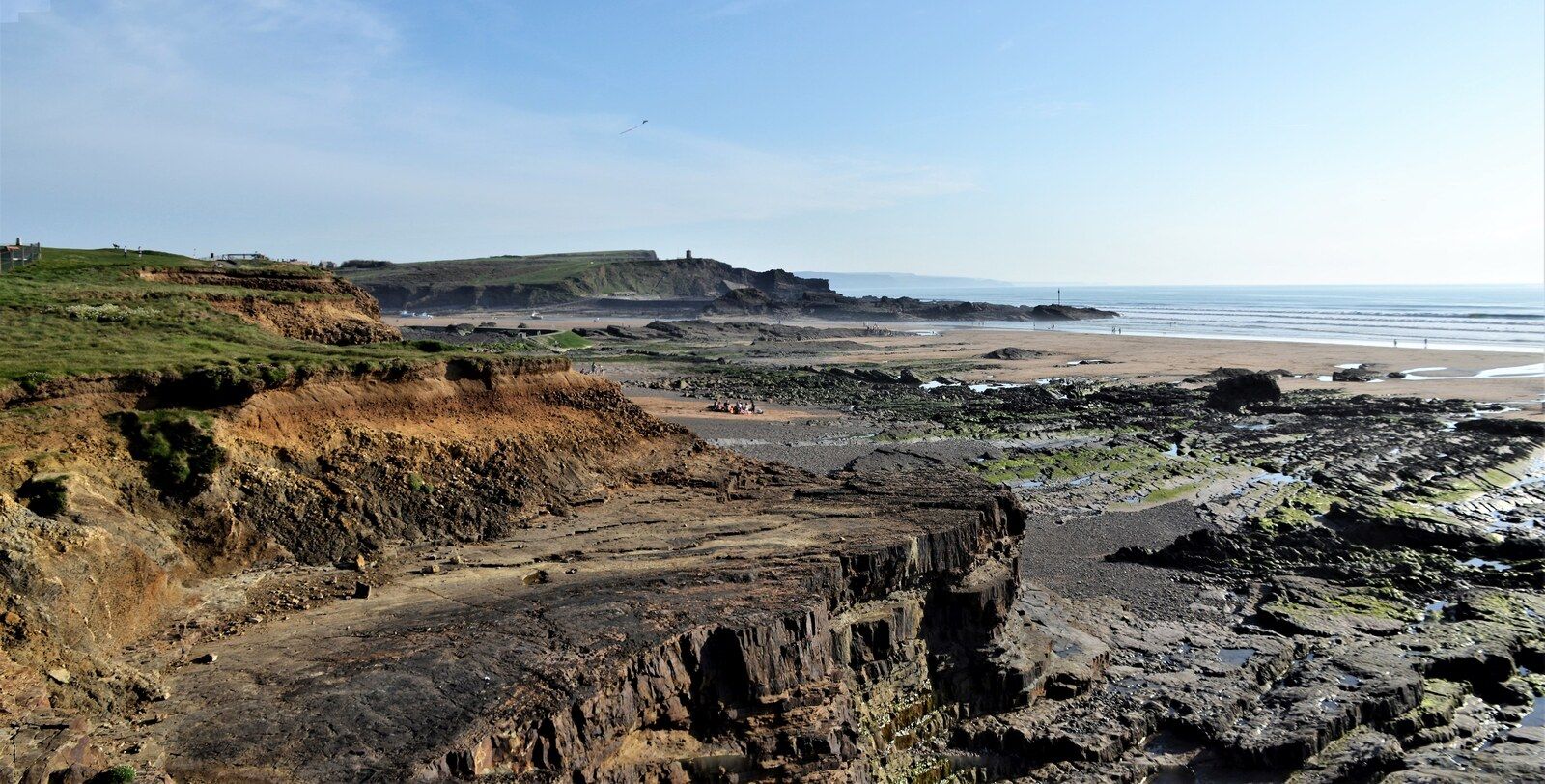 Low-tide rock shelves, sandy beach and clean surf lines at Crooklets