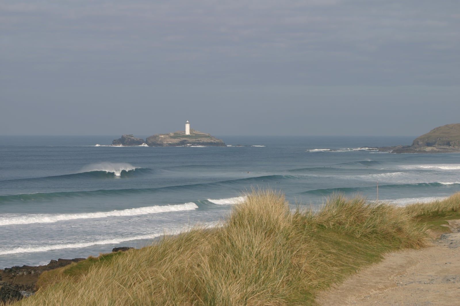 Clean surf lines at Gwithian with Godrevy lighthouse beyond