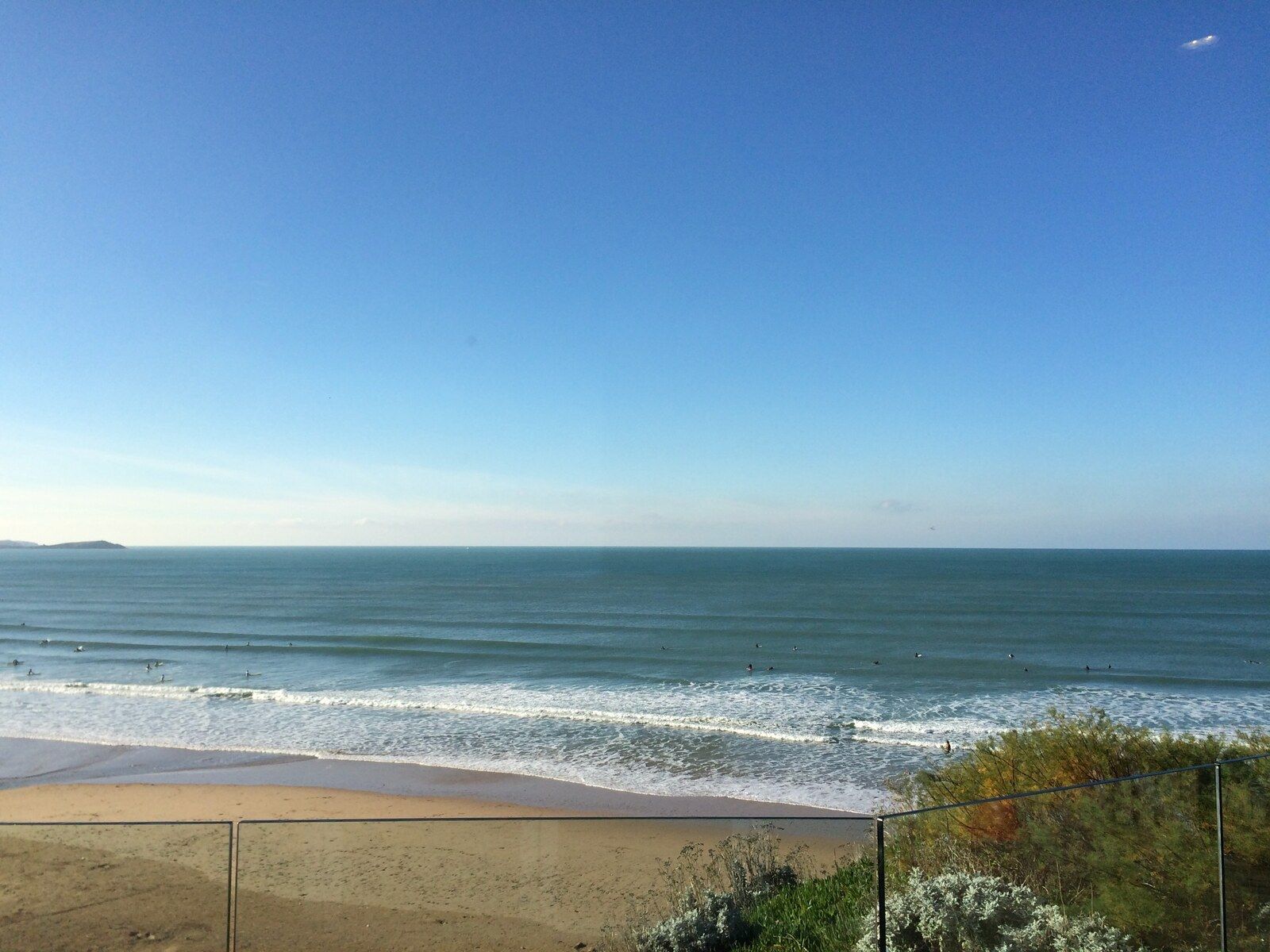 Clean surf lines approaching Watergate Bay with surfers waiting between the peaks